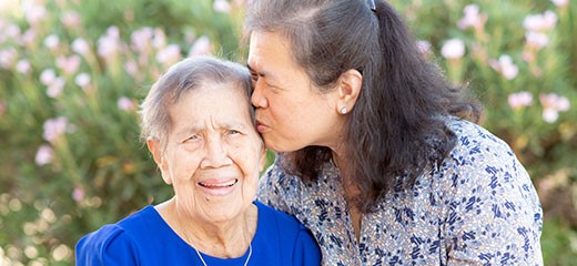 Daughter kissing mother on the forehead