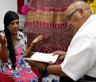 Chaplain Cristiano Artigas visits patient Maria Estrada Hernandez at her west Phoenix home