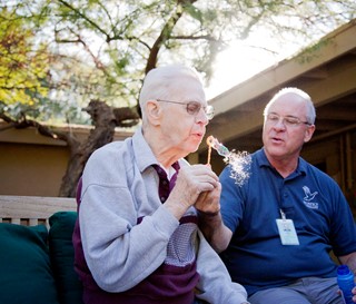 Male dementia patient blowing bubbles with volunteer at Gardiner Home