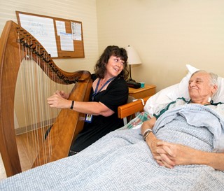 Harpist plays peaceful music for a patient. 