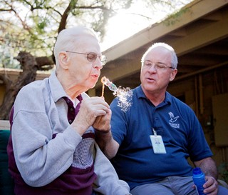 Hospice of the Valley volunteer blows bubbles with a person with dementia. 