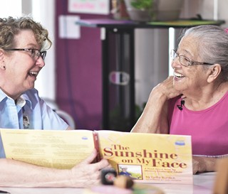 CNA enjoys reading a book to a dementia patient