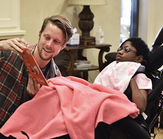 Chris Bean reads to patient Fatima Faye