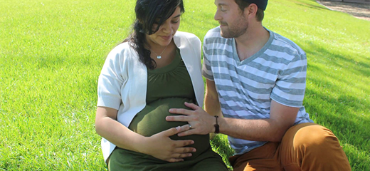 Husband with pregnant wife sitting in park