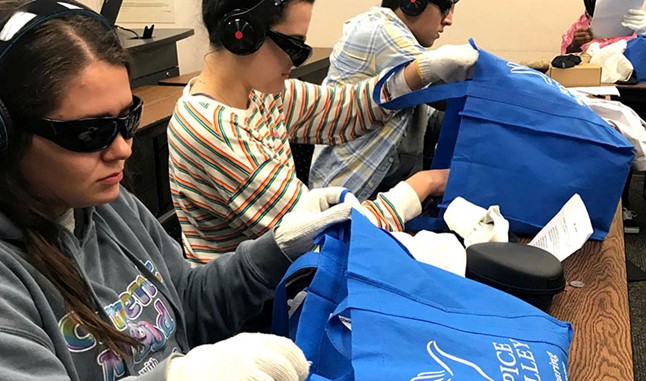 Students wearing sunglasses, gloves, and headphones