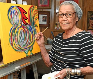 Mary Lou Salazar painting rooster on yellow canvas