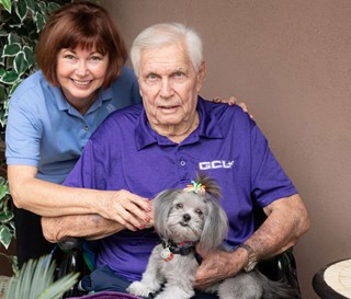 Volunteer Diane Bykowski and her therapy dog, Mia, visit with Bruce Moses