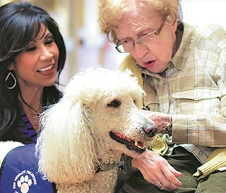 Lin Sue Cooney and her dog Max visit with patient