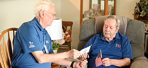 Volunteer Larry Petrowsky salutes veteran patient Ronald League