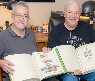 Phoenix Philatelic Association president Kevin Lesk, left, admires Monroe Wingate’s stamp collection.