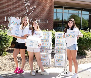Elina Ferrigno and Sammi Hampton are all smiles with Milan Coraggio-Sewell helping with the Boxed Up Project