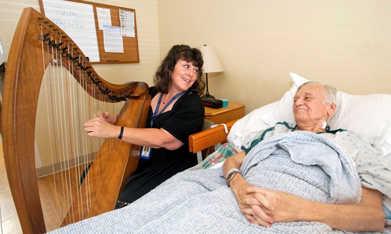 Harpist Joyce Obermeyer plays for patient