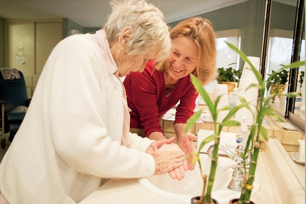 HOV staff member helps patient wash her hands