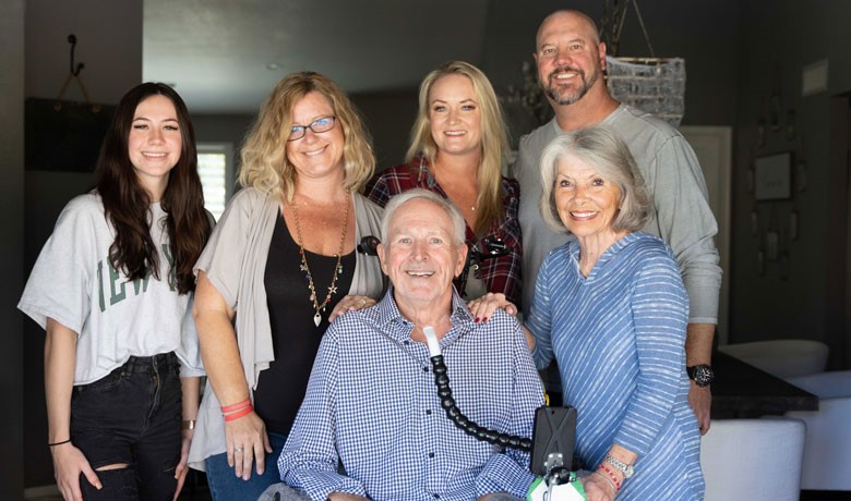 A patient with ALS smiling with his family