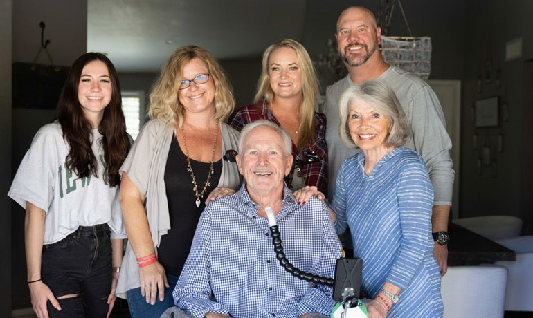 A patient with ALS smiling with his family
