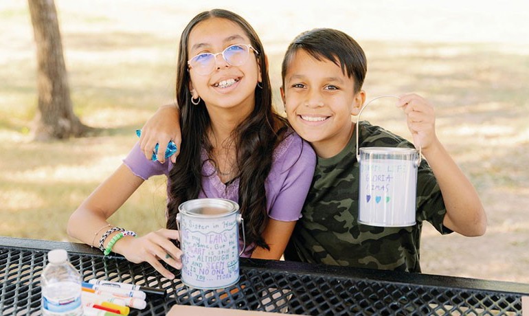 Celeste and Adam Estrada pose with art supplies