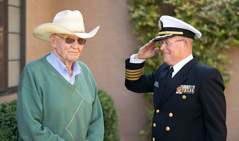 Man in dress uniform salutes older man