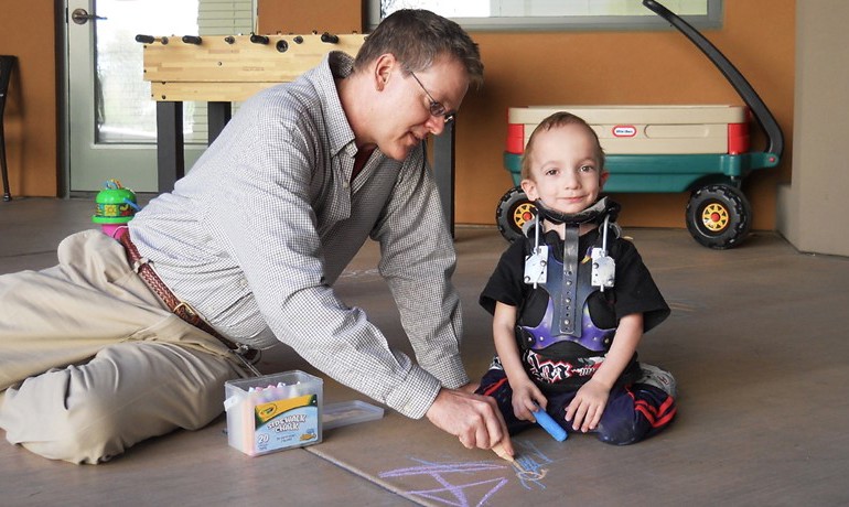 Volunteer playing with small child at Ryan House