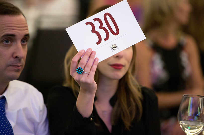 Woman holding auction bid card