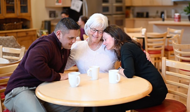 Small group hugging around a table