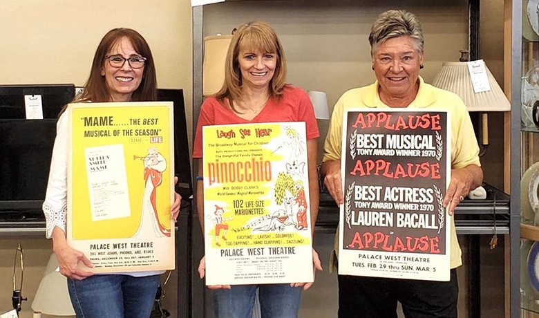 Laura Stenzel (FOTOT), Melody Mountain (White Dove General Manager), and Sue Livengood (White Dove Volunteer) pose together with theater posters