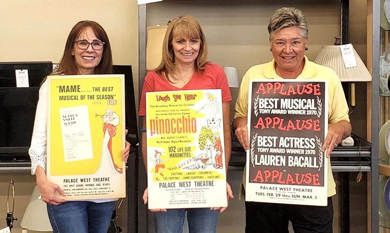Laura Stenzel (FOTOT), Melody Mountain (White Dove General Manager), and Sue Livengood (White Dove Volunteer) pose together with theater posters