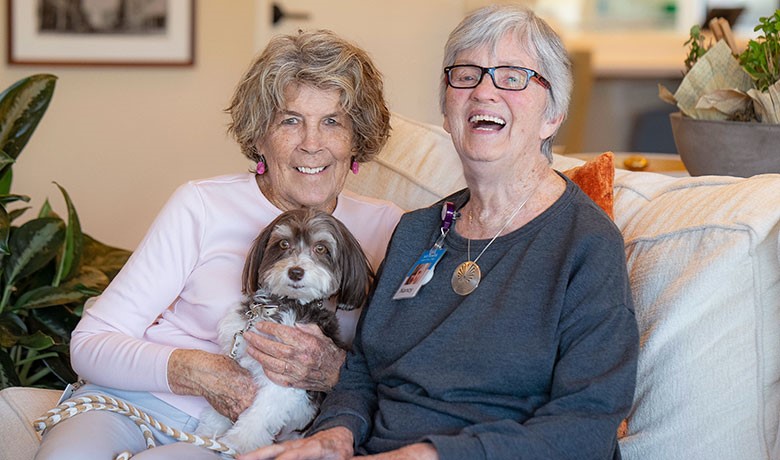 Volunteer Nancy Kelso and small dog Coco Chanel pose with patient Nancy Clark at the DCEC