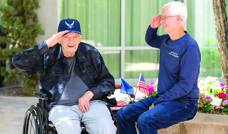 Volunteer Tom Kasbeer honors patient Bill with a salute for his service