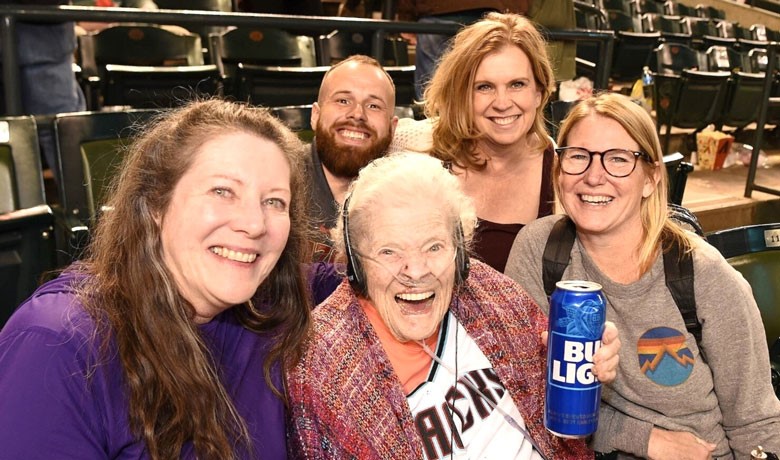 Myra Blaker smiles with HOV caregivers and family members at the game