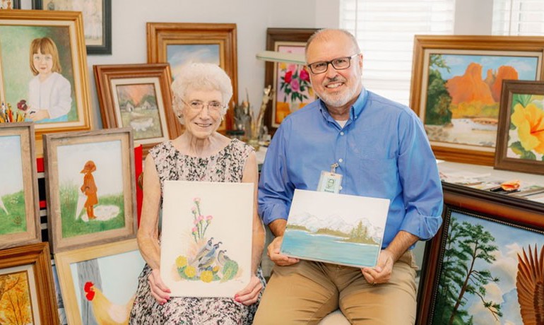 Artist Avinell MacDonald and chaplain Ken Collins pose with their art