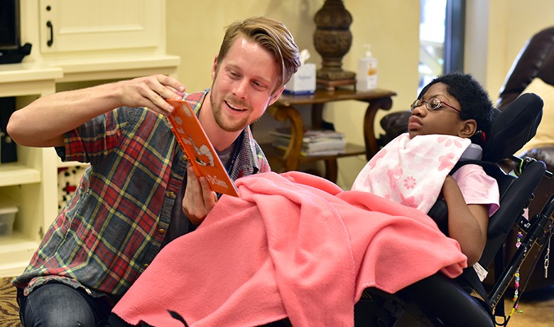 College student reading book to young patient