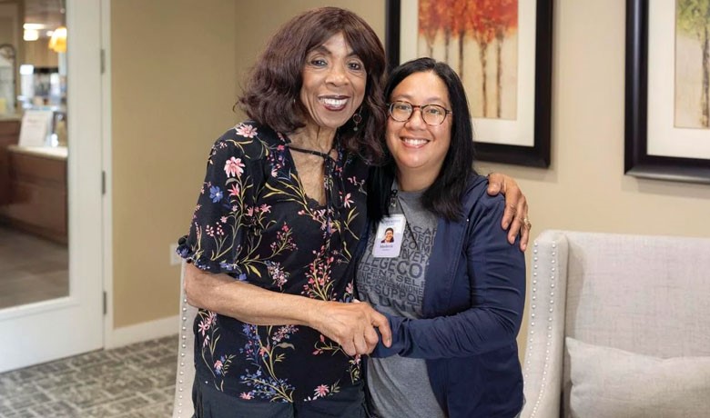 Volunteer Merle Tamondong smiling with HOV patient Micheline