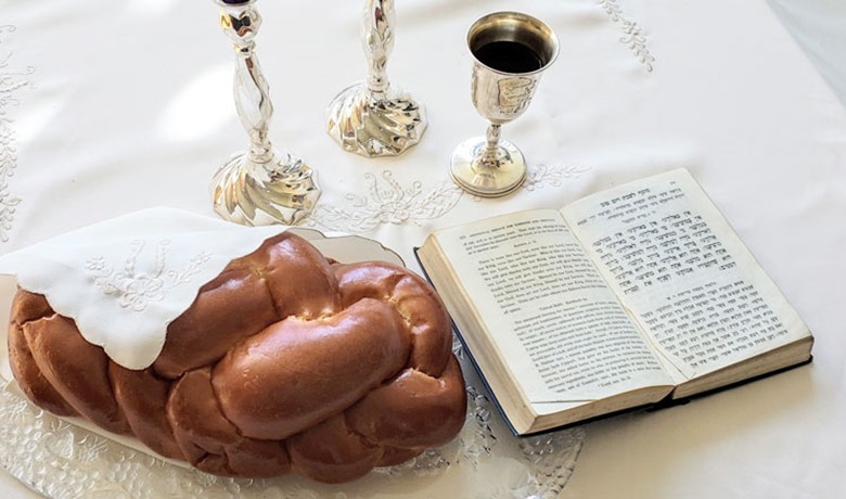 Challah bread with cup and book