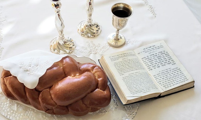 Challah bread with cup and book