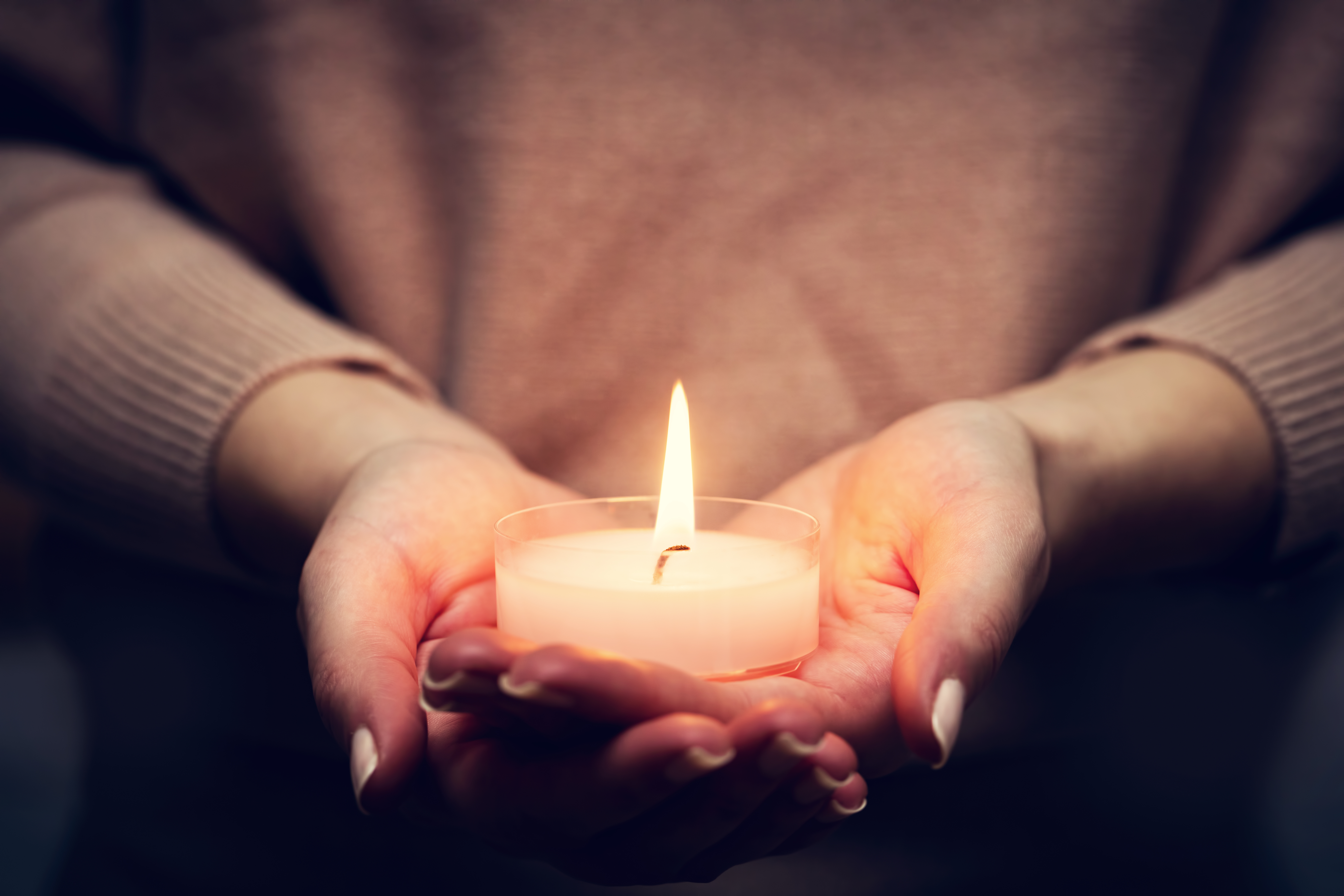 hands holding lit candle