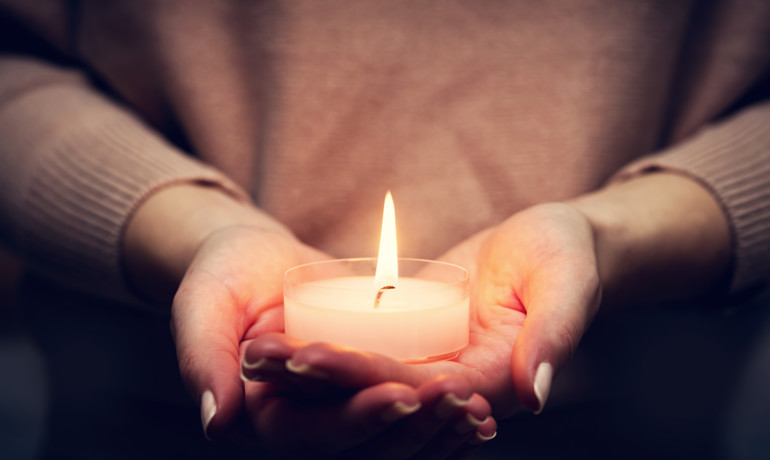 Hands holding candle for Light Up a Life event