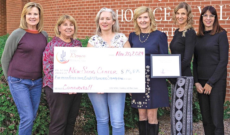 Six women from HOV and 100+ Women Who Care standing with a large donation check to the HOV New Song Center