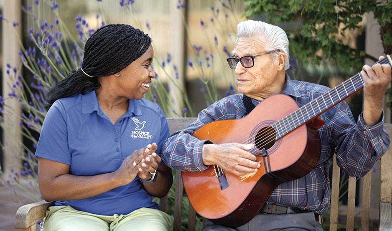 Patient Feliciano playing guitar with Danae Holt, CNA