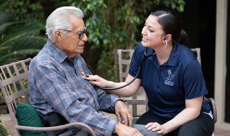 Nurse checking patient's heart with stethoscope