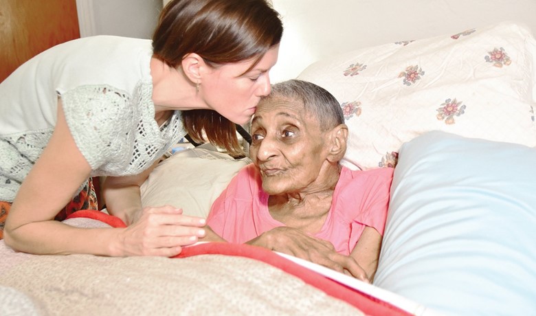 Social worker Erin Butler kisses patient Tressie Jennings on the forehead.