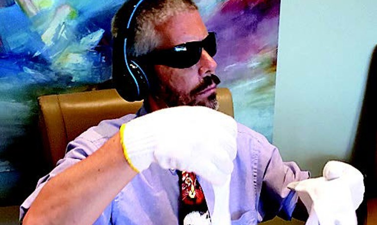 Man wearing dementia simulation gloves, goggles, and headphones