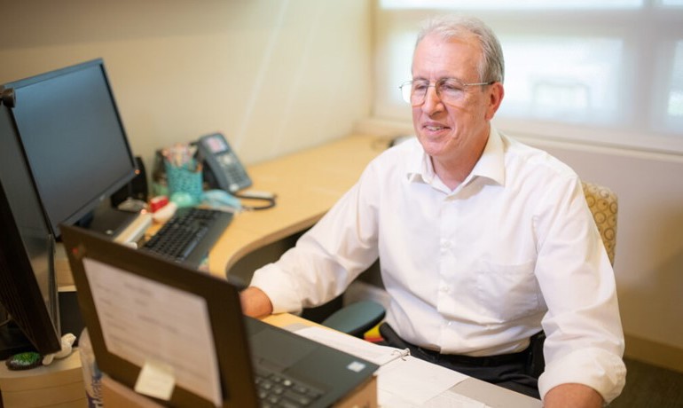 Bob Barrett at desk with laptop