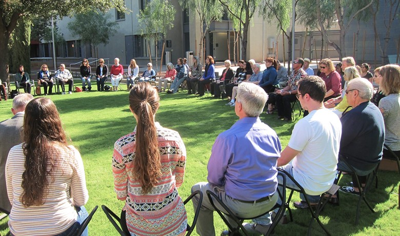 People seated in large circle outside practicing mindfulness 